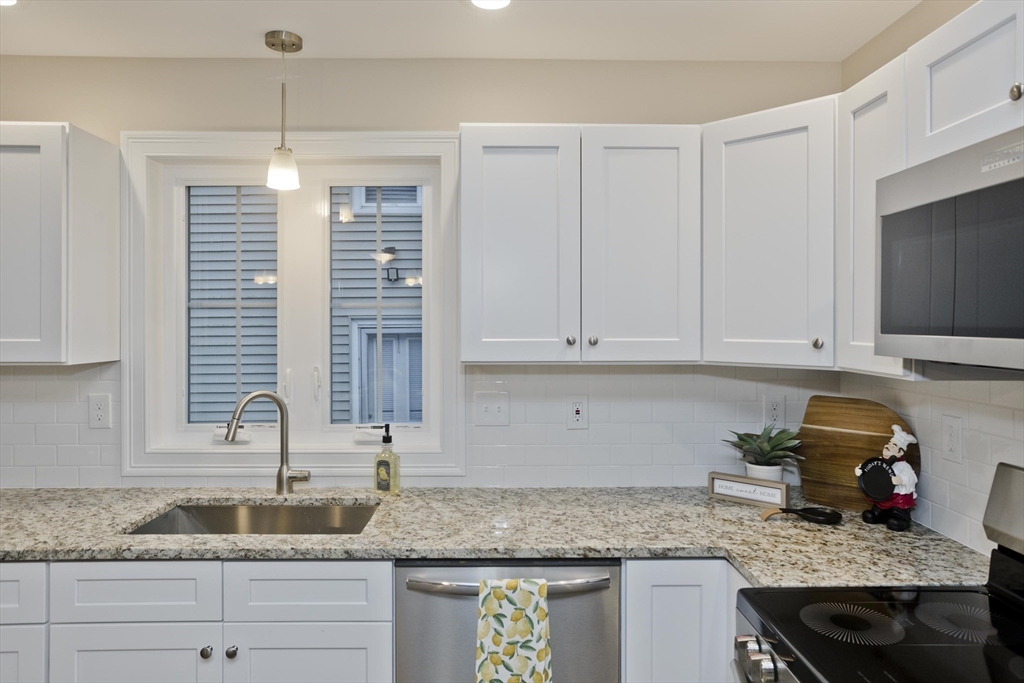 40 Preston Street Springfield, MA 01109 - Photo 5 of 32 a kitchen with granite countertop a sink a stove and cabinets