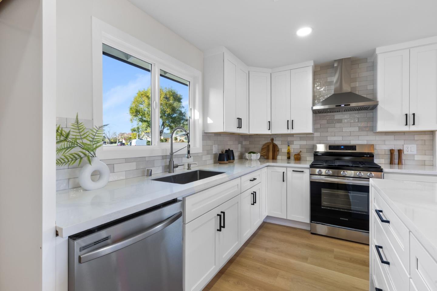 390 Valmy Street Milpitas, CA 95035 - Photo 15 of 37 a kitchen with stainless steel appliances white cabinets a sink and a stove