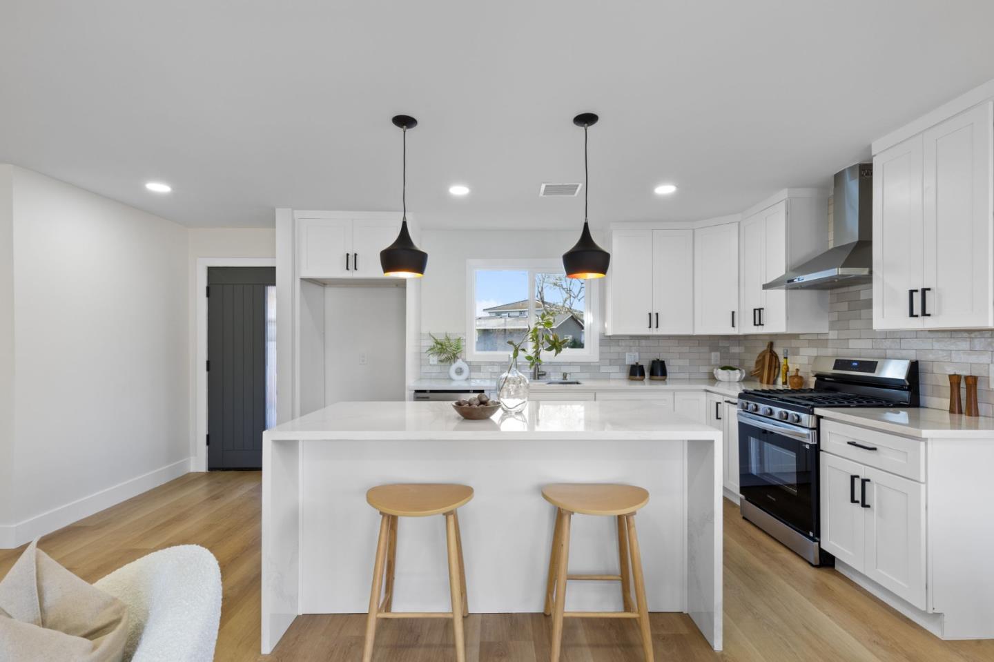 390 Valmy Street Milpitas, CA 95035 - Photo 6 of 37 a kitchen with stainless steel appliances granite countertop a stove a sink a kitchen island with chairs and white cabinets