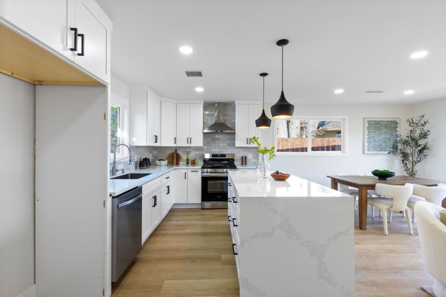 390 Valmy Street Milpitas, CA 95035 - Photo 8 of 37 a kitchen with kitchen island stainless steel appliances sink cabinets and wooden floor