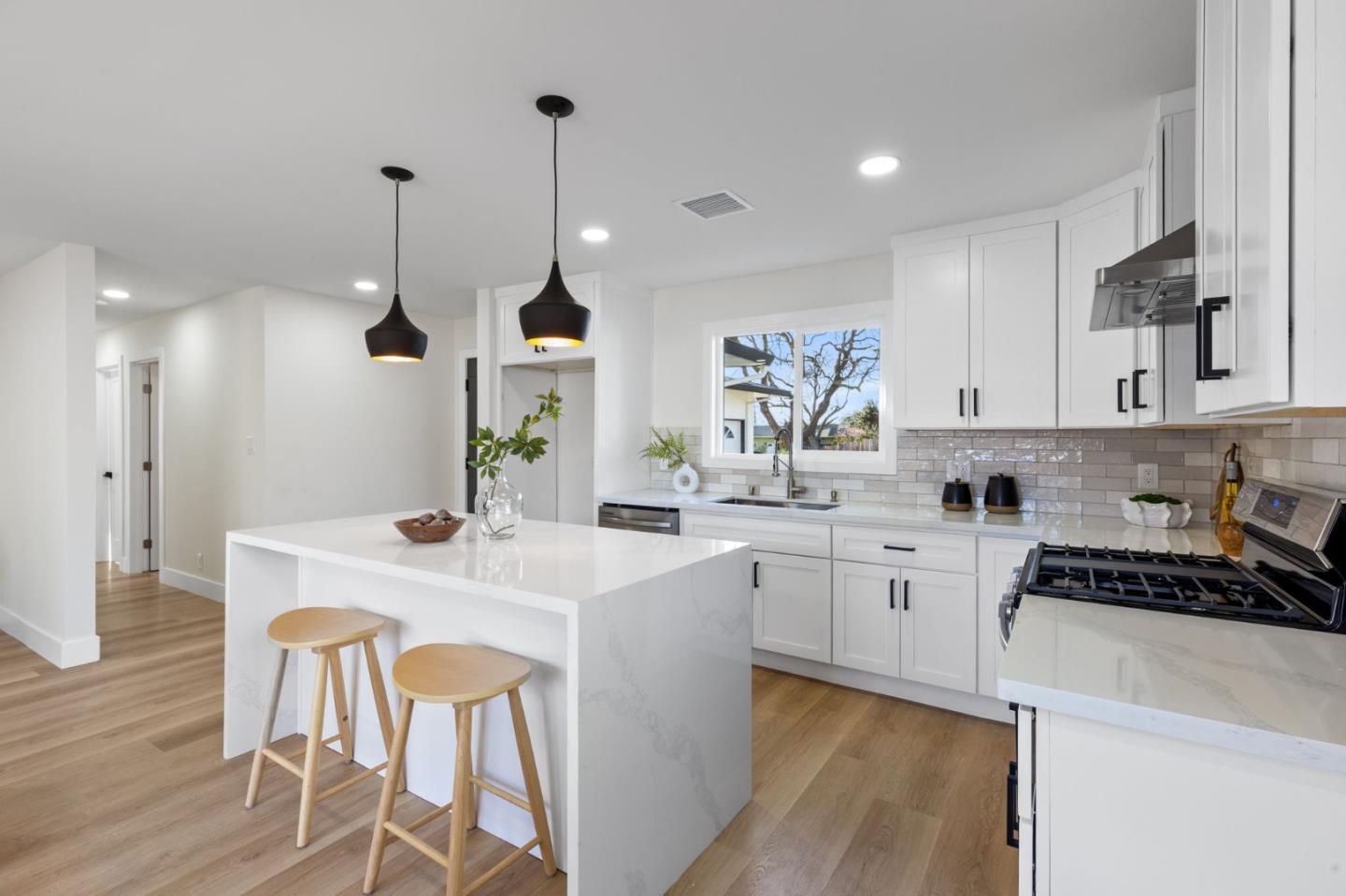 390 Valmy Street Milpitas, CA 95035 - Photo 10 of 37 a kitchen with kitchen island a stove a table a sink and cabinets