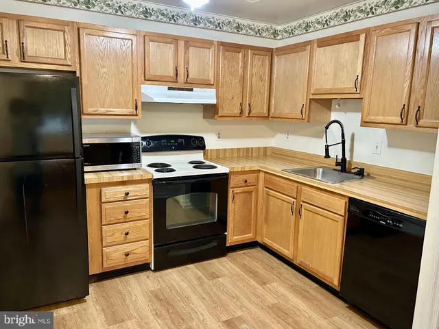 a kitchen with stainless steel appliances granite countertop a refrigerator sink and cabinets