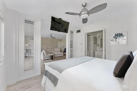 a bedroom with a bed window and a flat screen tv