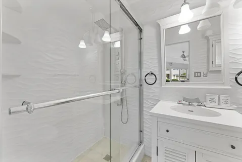 a bathroom with a shower sink vanity and mirror
