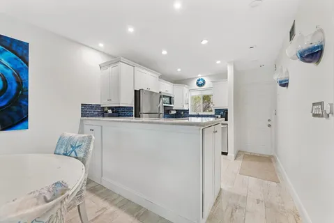 a kitchen with stainless steel appliances granite countertop a refrigerator and a stove top oven