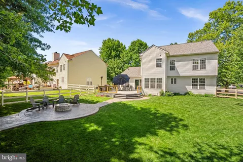 a view of a white house with a big yard and large trees