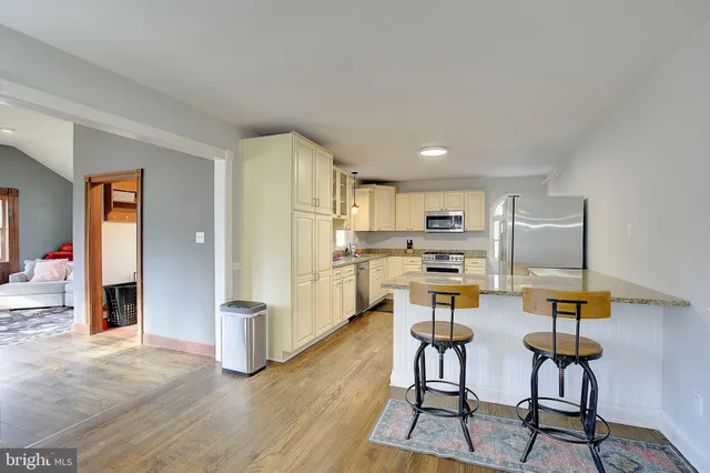 a kitchen with granite countertop white cabinets stainless steel appliances and sink