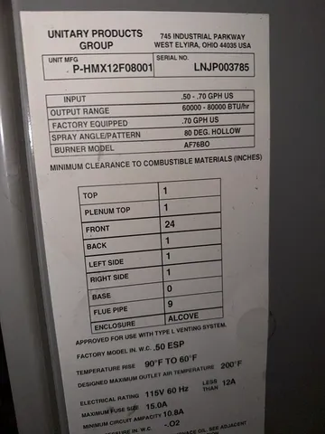 a brick house with a small yard and a large tree