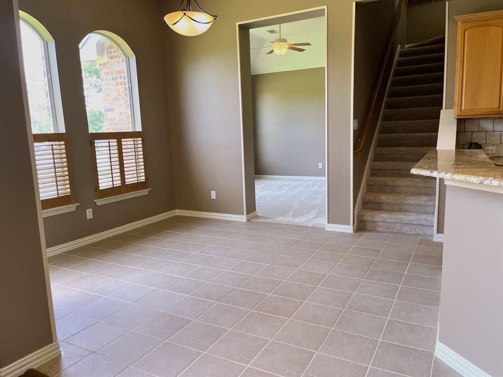 7517 Rodeo Drive Denton, TX 76208 - Photo 19 of 39 The spacious breakfast area is open to the kitchen and living room - also features wood shutters for privacy. The flex room is also shown here, along with the stairway to the game room.