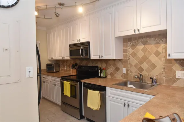 a kitchen with stainless steel appliances granite countertop a sink a stove and a microwave