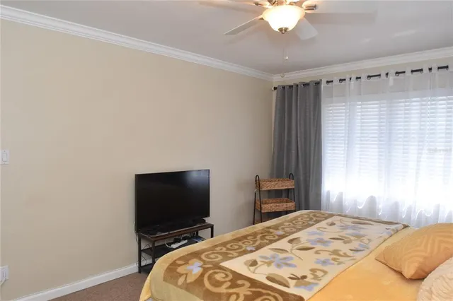 a bedroom with a bed and a flat tv screen on the dresser
