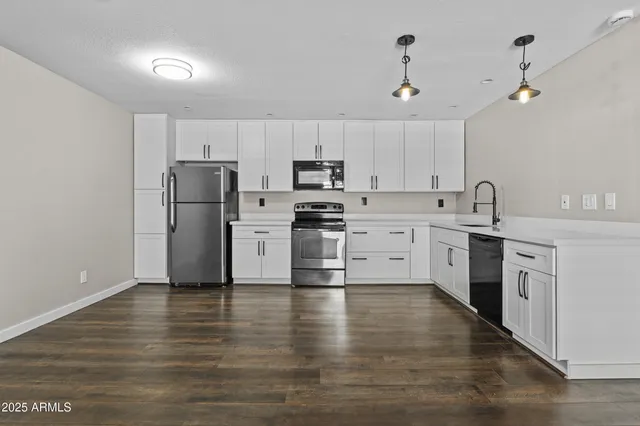 a kitchen with stainless steel appliances a refrigerator sink and stove top oven