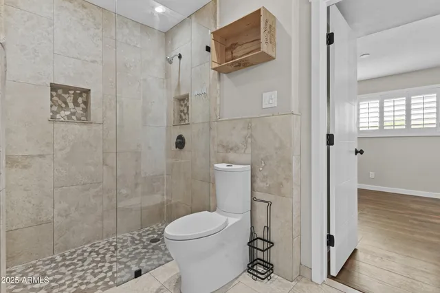 a bathroom with a toilet and a shower