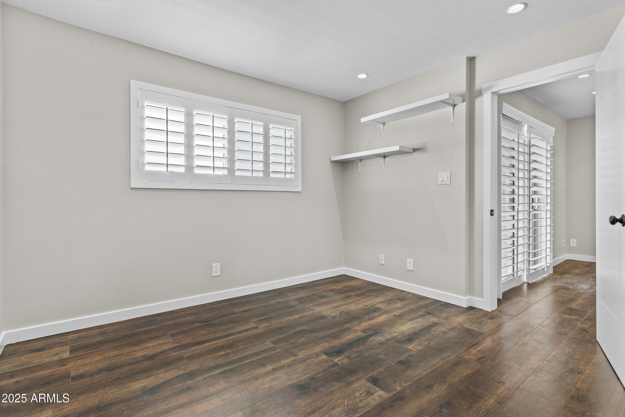 5525 East Thomas Road, Unit K16 Phoenix, AZ 85018 - Photo 18 of 36 a view of an empty room with wooden floor and a window