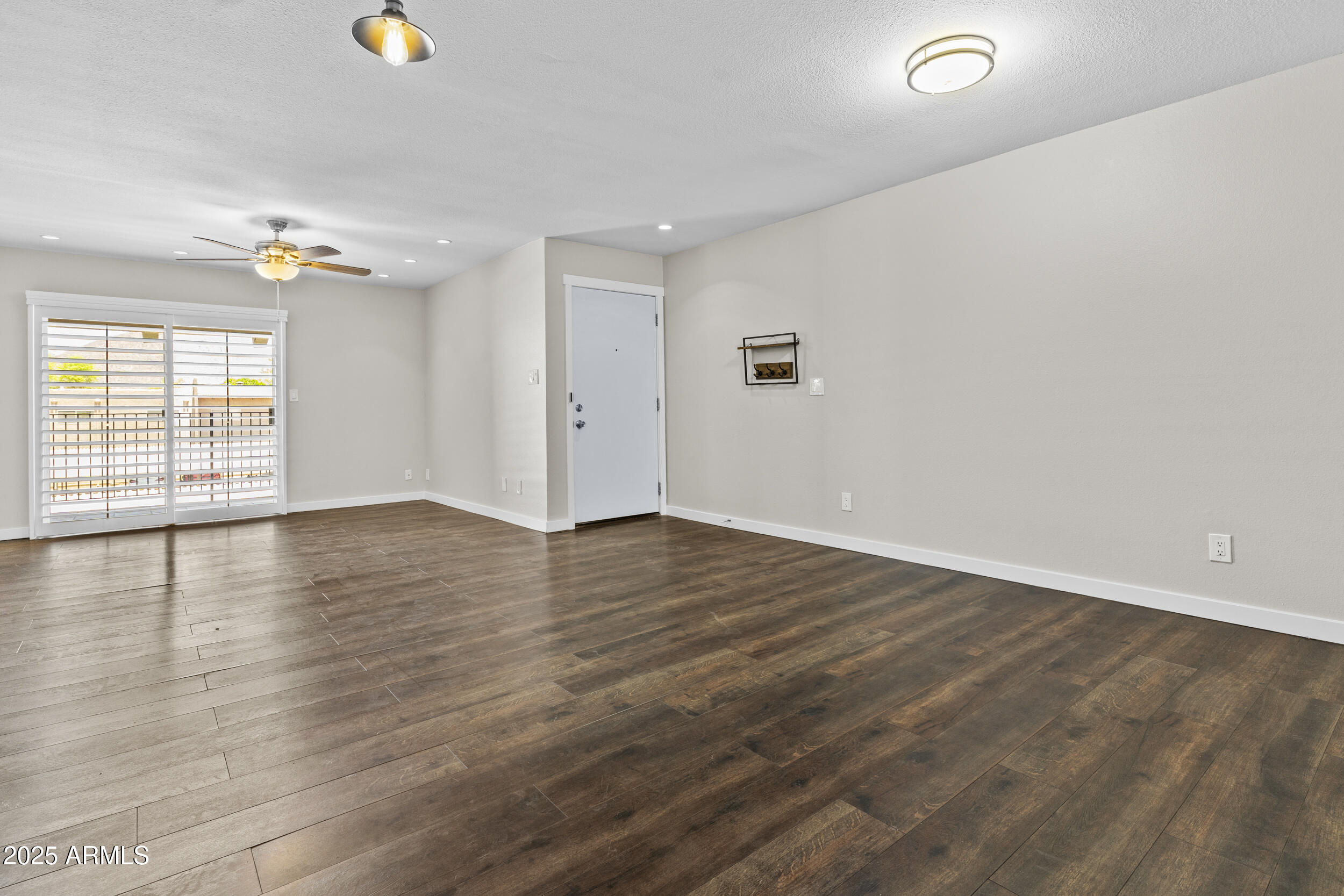 5525 East Thomas Road, Unit K16 Phoenix, AZ 85018 - Photo 8 of 36 an empty room with wooden floor and windows