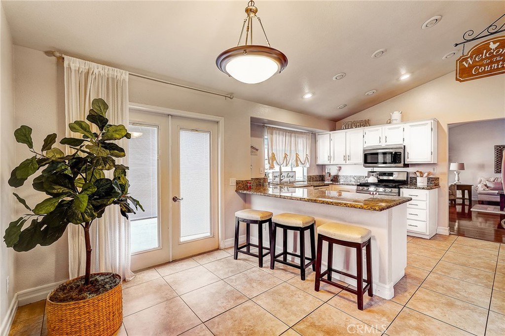 4920 Meadowland Drive Riverside, CA 92509 - Photo 12 of 28 a kitchen with stainless steel appliances granite countertop a refrigerator a stove a sink a microwave and cabinets