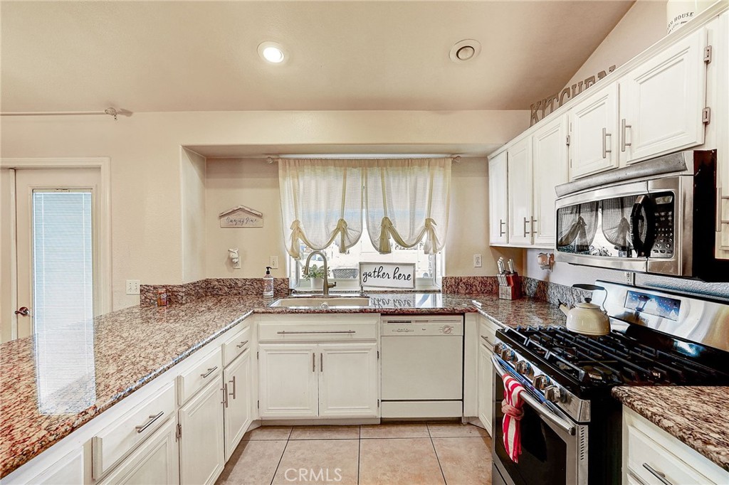 4920 Meadowland Drive Riverside, CA 92509 - Photo 13 of 28 a kitchen with granite countertop a sink stove and cabinets