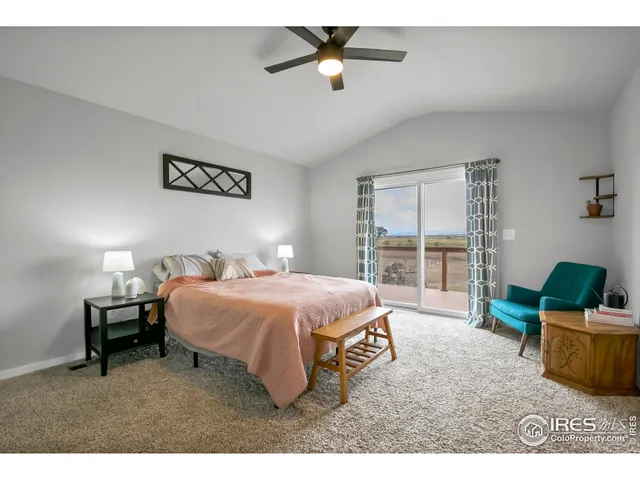 a spacious bedroom with a bed a couch and a chandelier