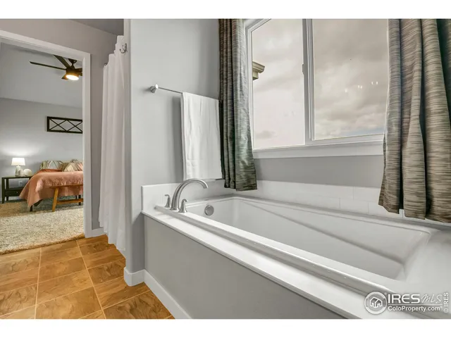 a en suite bathroom with a tub sink and mirror