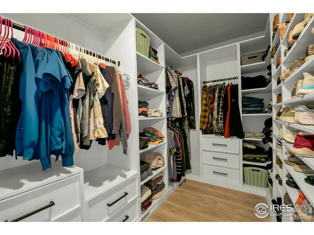 a view of walk in closet with clothes and shoes
