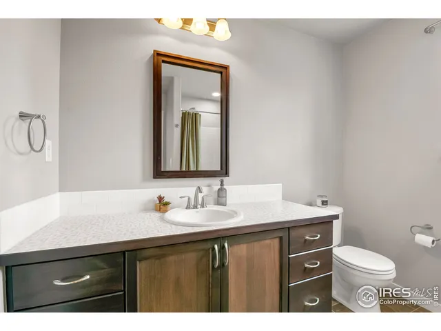 a bathroom with a toilet sink vanity and mirror