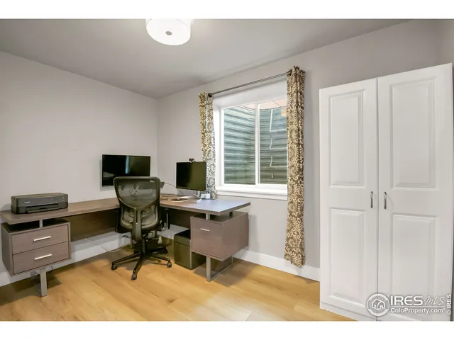 a view of a workspace with furniture and a window