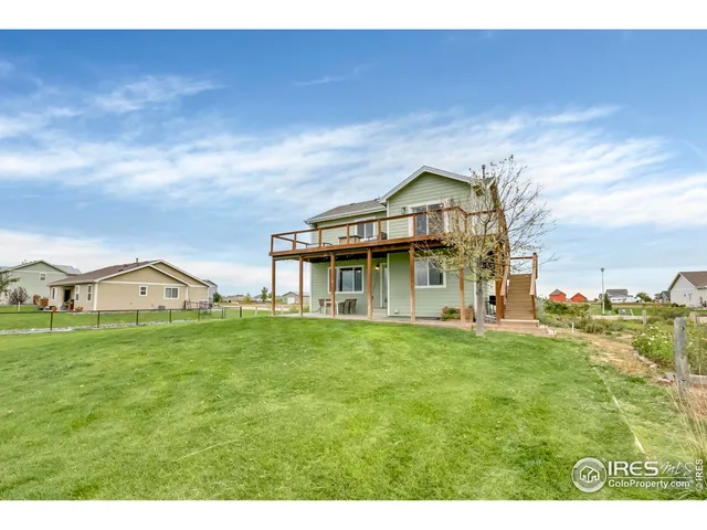 a view of a big house with a big yard and large trees