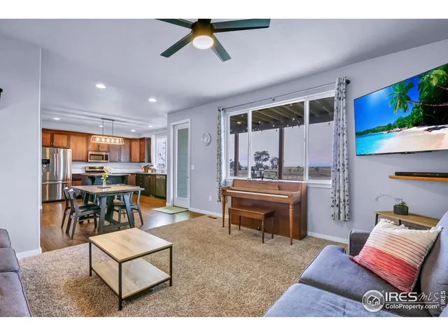 a living room with furniture a flat screen tv and floor to ceiling window