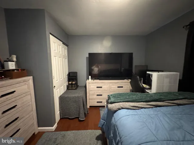 a bedroom with a bed and flat tv screen on the dresser