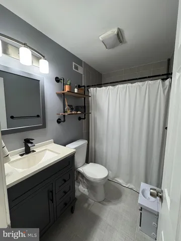 a bathroom with a double vanity sink toilet and mirror