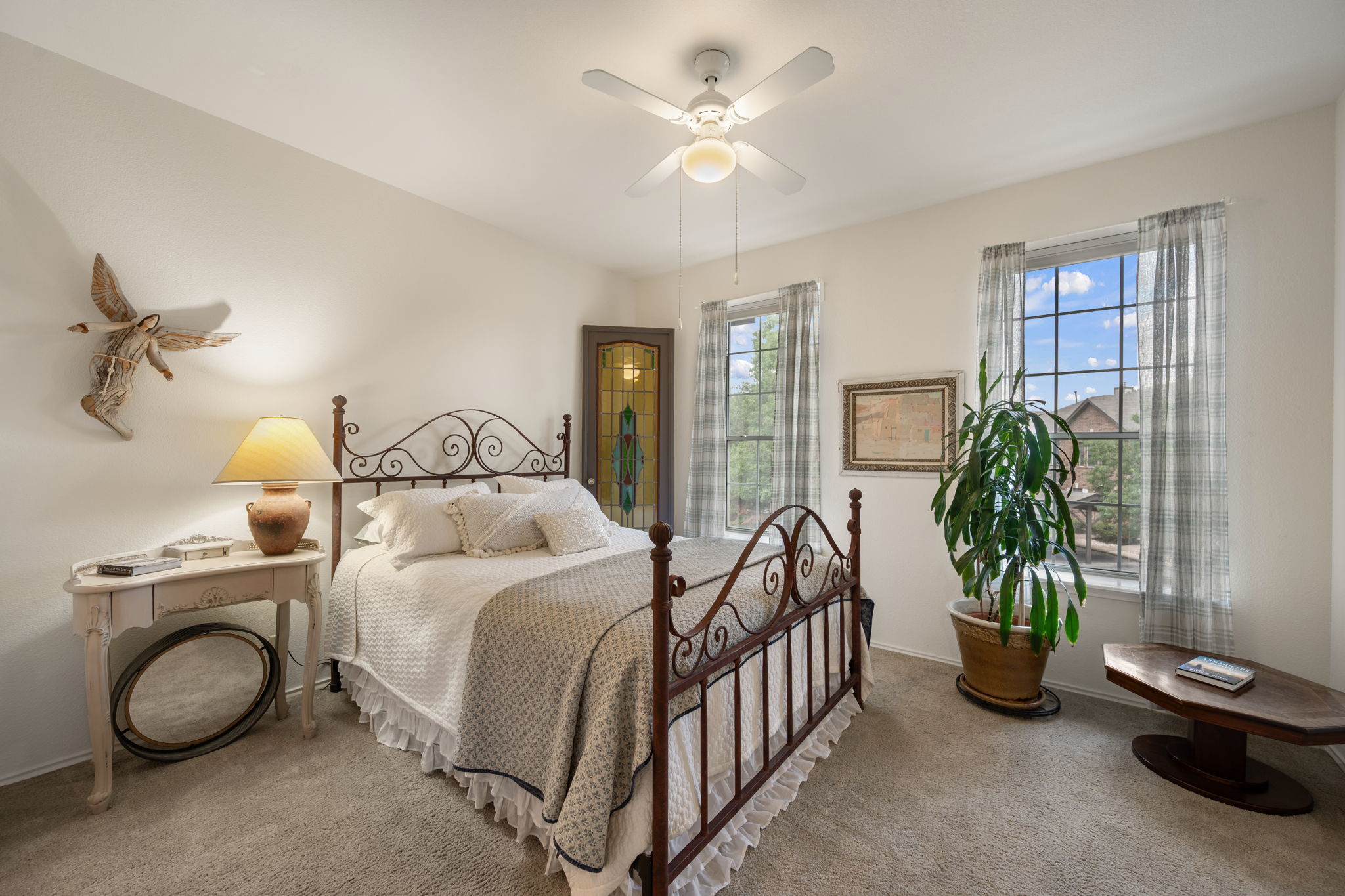 12401 Los Indios Trail, Unit 32 Austin, TX 78729 - Photo 22 of 39 Restful bedroom retreat with a graceful wrought iron bed, plush carpeting, and charming window views.