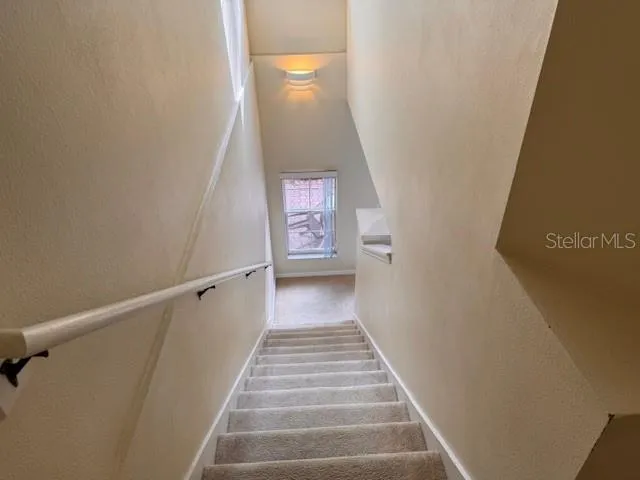 a view of a hallway with wooden floor and stairs
