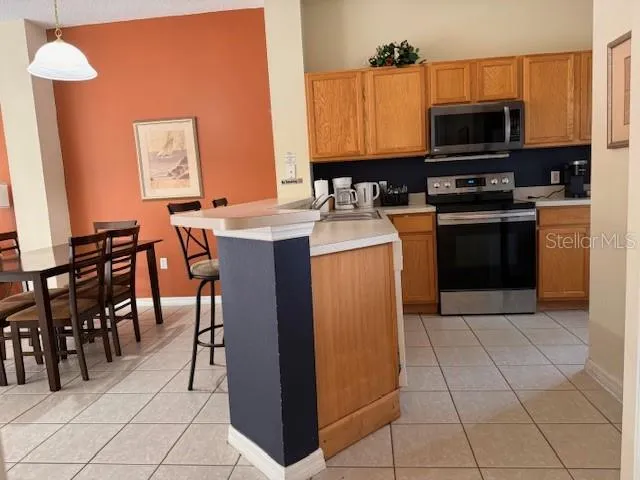 a kitchen with stainless steel appliances a stove a sink a microwave and a refrigerator