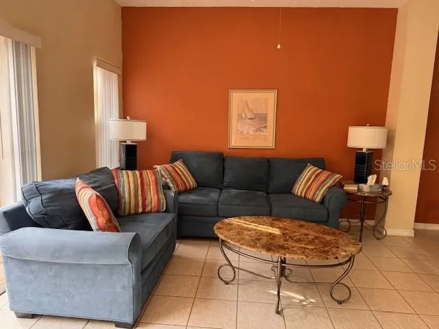 a living room with furniture and a lamp