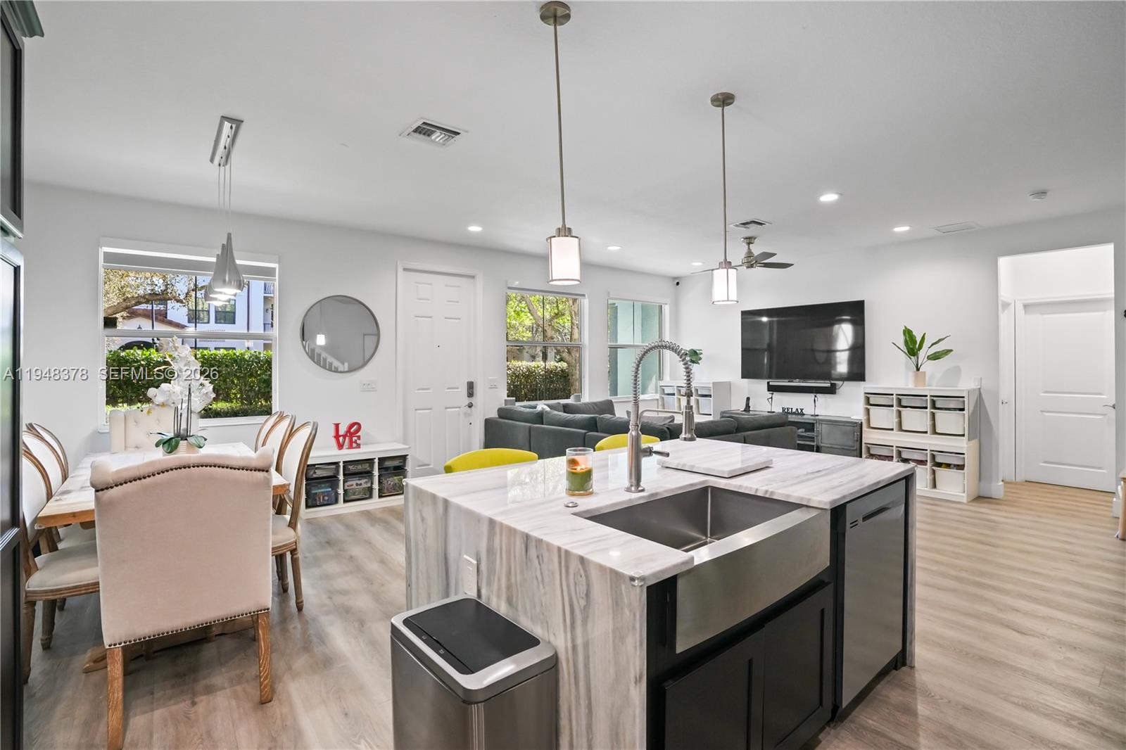 2913 Cascada Isle Way Cooper City, FL 33024 - Photo 12 of 50 a view of kitchen with kitchen island stainless steel appliances a table chairs sink and wooden floor