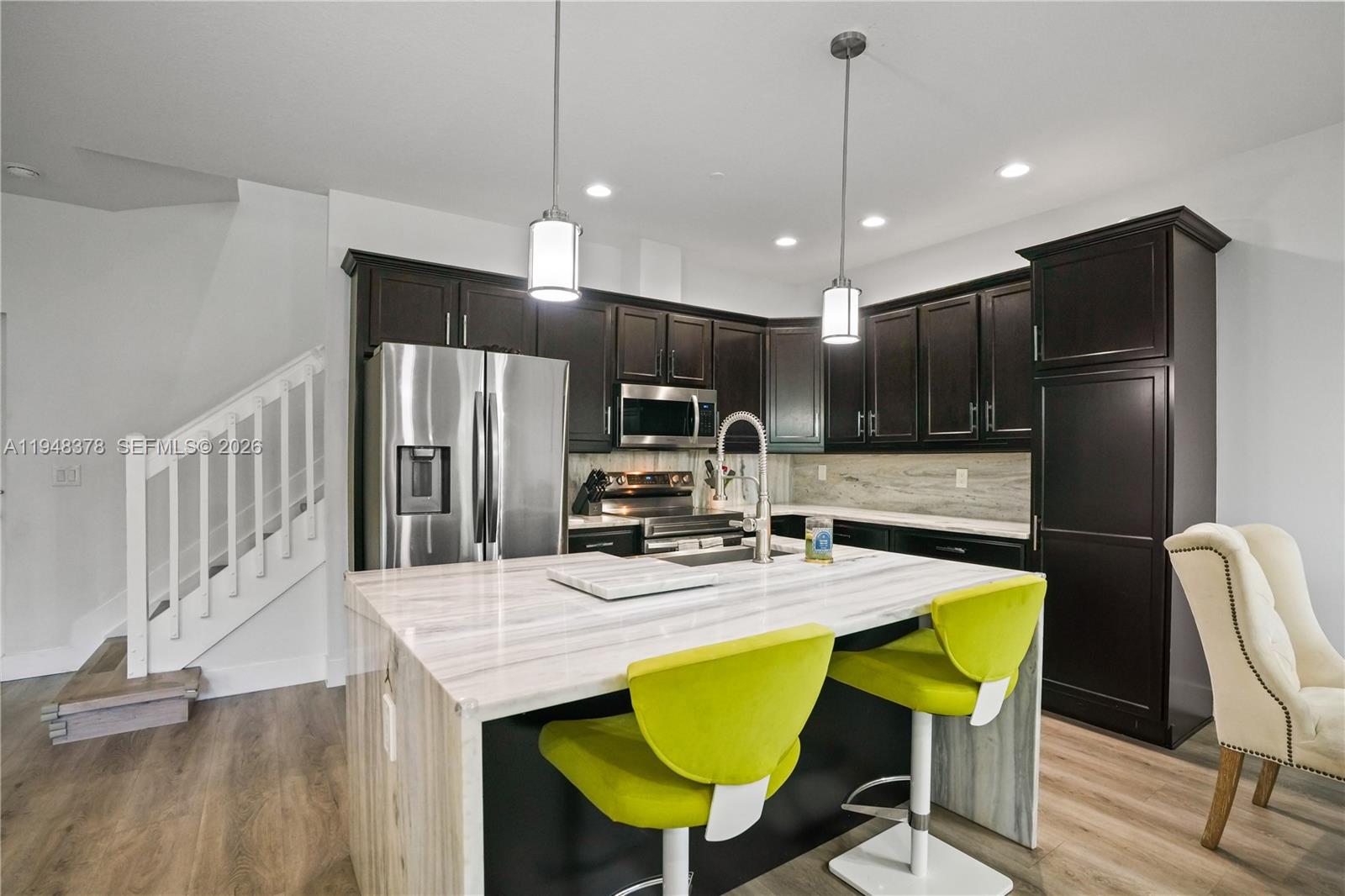 2913 Cascada Isle Way Cooper City, FL 33024 - Photo 9 of 50 a kitchen with stainless steel appliances kitchen island granite countertop a refrigerator a stove a kitchen island with a dining table and chairs