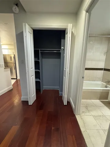 a view of walk in closet with wooden floor and stairs