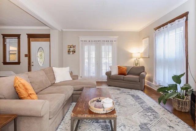 a living room with a couch and a dresser next to a window