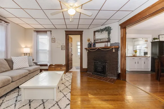 a view of a dining room and livingroom with furniture wooden floor a chandelier