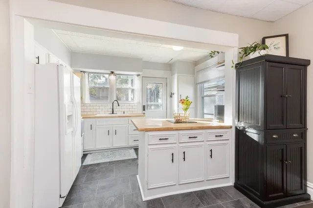 a kitchen with stainless steel appliances kitchen island granite countertop a dining table and chairs