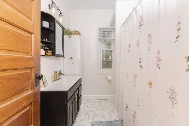 a bathroom with a toilet sink vanity and mirror