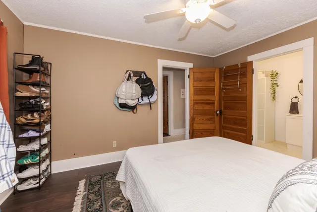 a bedroom with a bed and a dresser with wooden floor