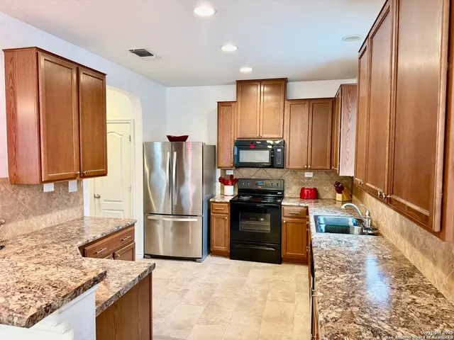 a kitchen with stainless steel appliances granite countertop a refrigerator stove and oven