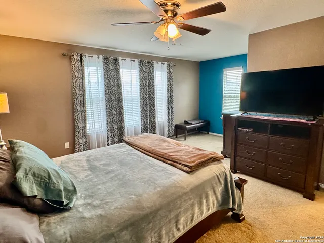 a bedroom with a bed and a flat tv screen on dresser