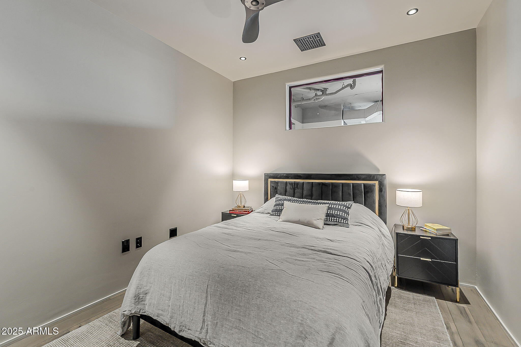 2211 East Camelback Road, Unit 605 Phoenix, AZ 85016 - Photo 16 of 23 a bedroom with a bed and wooden floor