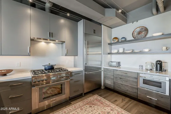 a kitchen with stainless steel appliances a stove a sink and cabinets