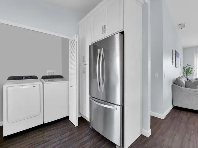 a kitchen with stainless steel appliances a refrigerator and a hard wood floor