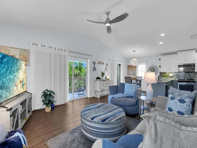 a living room with furniture a window and wooden floor