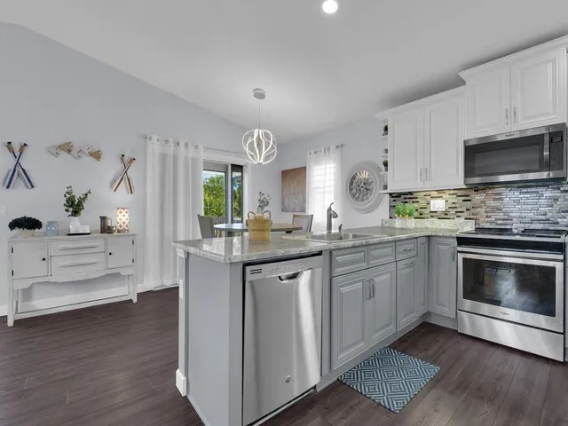 a kitchen with granite countertop a sink stove and microwave