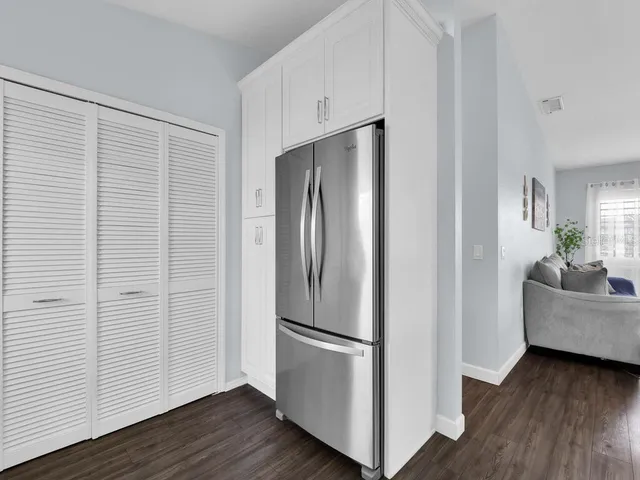 a view of kitchen with stainless steel appliances wooden floor